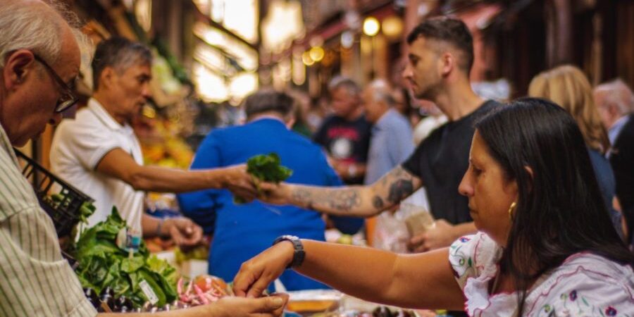 woman wearing white and red blouse buying some veggies